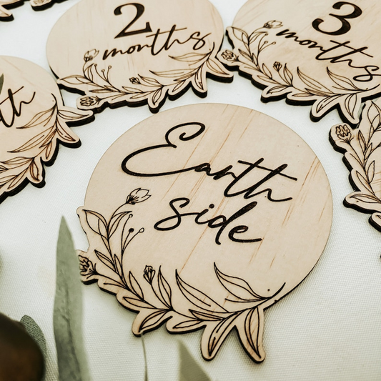 Floral baby milestone discs handmade from eco-friendly engraved wood, designed as a 13-piece monthly keepsake photo set. Each disc marks a milestone from newborn to one year, with delicate floral designs that suit any baby photo style. Ideal as a thoughtful newborn gift, baby shower present, or treasured keepsake to celebrate your baby’s growth month by month.
