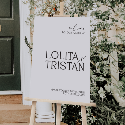 Wedding welcome sign on an easel with greenery in the background