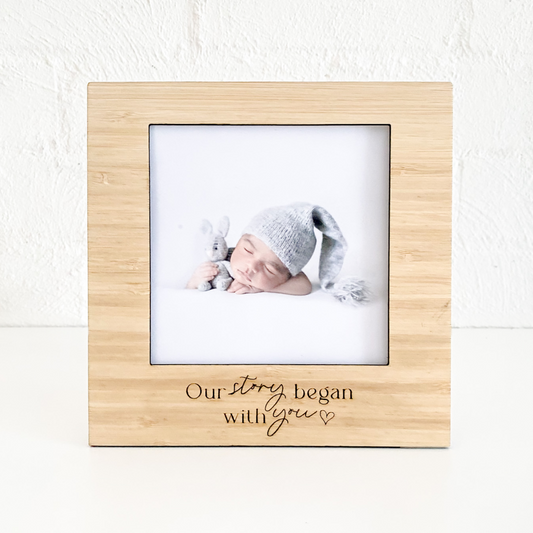 Our Story Begins with you wood picture frame. Wooden photo frame with a baby picture and engraved text on a white background by Bell & Beau Design Co