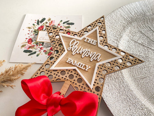 Custom rattan star tree topper with rustic wooden design, red ribbon bow, FSC plywood, eco friendly and sustainable Christmas décor.