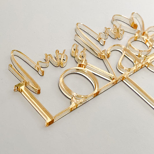 Personalised Gold Mr & Mrs acrylic wedding cake topper in mirrored gold finish, designed for modern brides and grooms. A stunning decorative piece that enhances wedding cakes, anniversaries, or engagement celebrations. Handmade in Australia, durable and elegant, this topper doubles as a keepsake to remember your day. Customised in colours and finishes to complement wedding décor and create unforgettable celebrations.