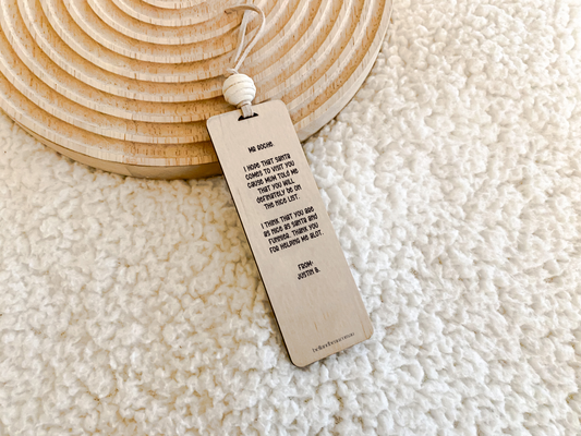 Flatlay of wooden teacher bookmark on neutral background with bead detail