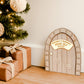 A handcrafted wooden Magic Elf Door with a brick-style arch, gold acrylic nameplate reading “ELF’S Magic Door,” and 3D white snowflake accents. A whimsical Christmas decoration for children to welcome their festive elf visitor. Personalised with children’s names, made from wood and acrylic, measuring 11 cm wide by 14 cm high.
