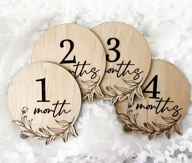 Earth Side baby milestone discs engraved with floral artwork, made from sustainable wood in a 13-piece set. Includes newborn through one year markers for photography and memory keepsakes. Neutral floral design makes these wooden discs a timeless prop for newborn photo shoots, baby showers, or first year celebrations. Handmade in Australia for parents wanting meaningful keepsakes.