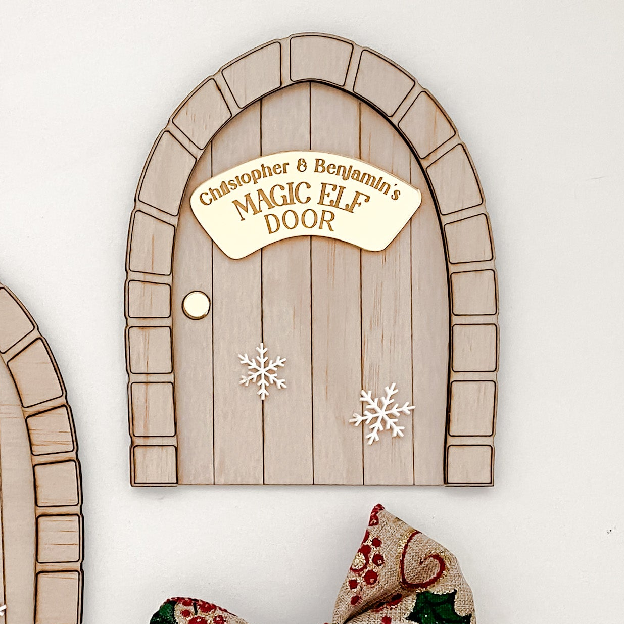 Christmas Elf Door with brick-style design, white snowflake details, and personalised name engraving option. A handcrafted wood and acrylic decoration that celebrates festive wonder and holiday charm.