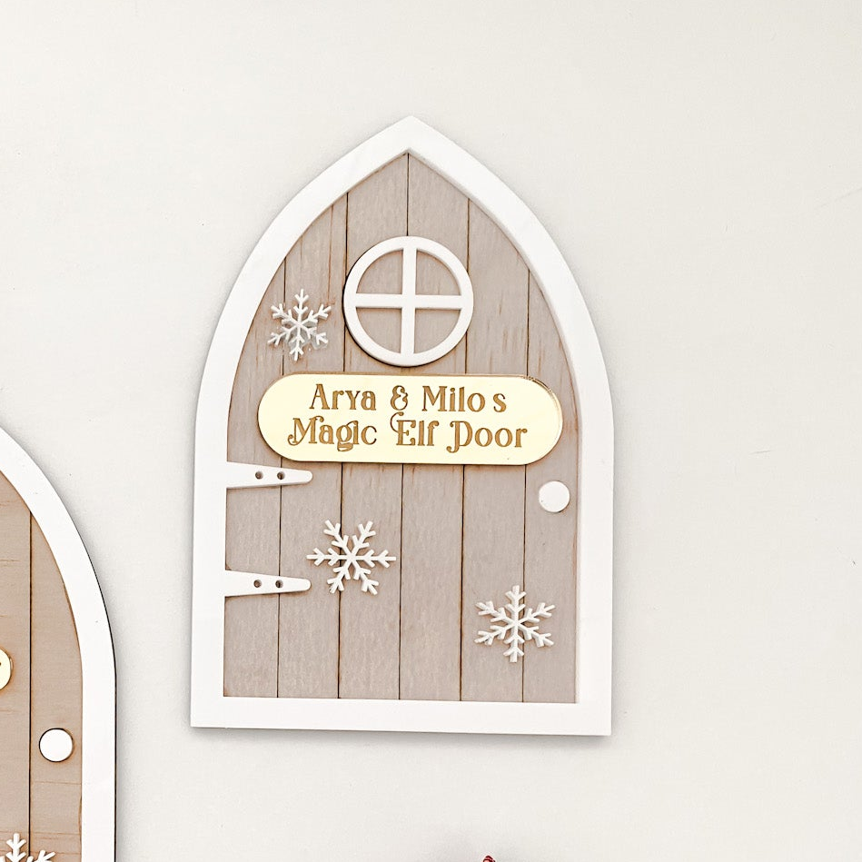 Rustic wooden Elf Magic Door with acrylic details, including white snowflakes and a custom gold name plaque. A timeless Christmas keepsake for children to enjoy year after year, encouraging imagination and festive joy. Designed and handmade in Australia, 11 cm wide × 14 cm high, perfect for placing by the skirting board or Christmas tree.
