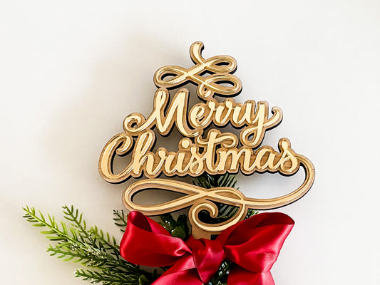 A handcrafted Merry Christmas Star Tree Topper made from layered wood and acrylic in gold lettering. This rustic Christmas tree decor features elegant 3D script text reading “Merry Christmas,” accented with festive greenery and a red satin ribbon. A timeless Christmas keepsake for family traditions and sustainable Christmas decorations, lovingly handmade in Australia by Bell & Beau Design Co.