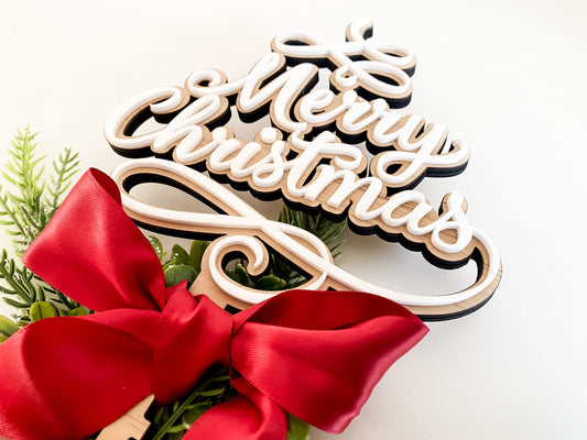 Elegant Christmas star tree topper alternative with layered white acrylic and wooden lettering that reads “Merry Christmas.” Styled with green pine sprigs and a luxurious red ribbon bow, this Christmas tree decor combines rustic charm with modern design. A meaningful family tradition piece and Christmas keepsake, sustainably handmade in Australia by Bell & Beau Design Co.