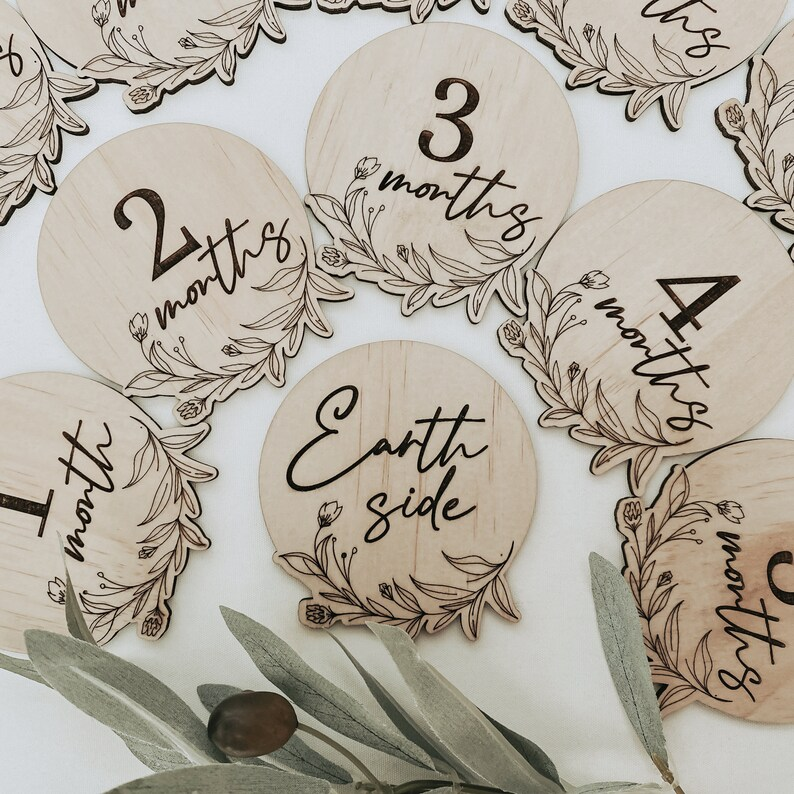 Newborn floral milestone disc set featuring 13 engraved wooden baby monthly markers. Includes “Hello World” through “One Year” for capturing your baby’s first milestones in photography sessions. Delicate floral artwork engraved on FSC-certified wood, handmade in Australia. Perfect as a baby shower gift, photo prop, or keepsake for parents cherishing their little one’s first year.