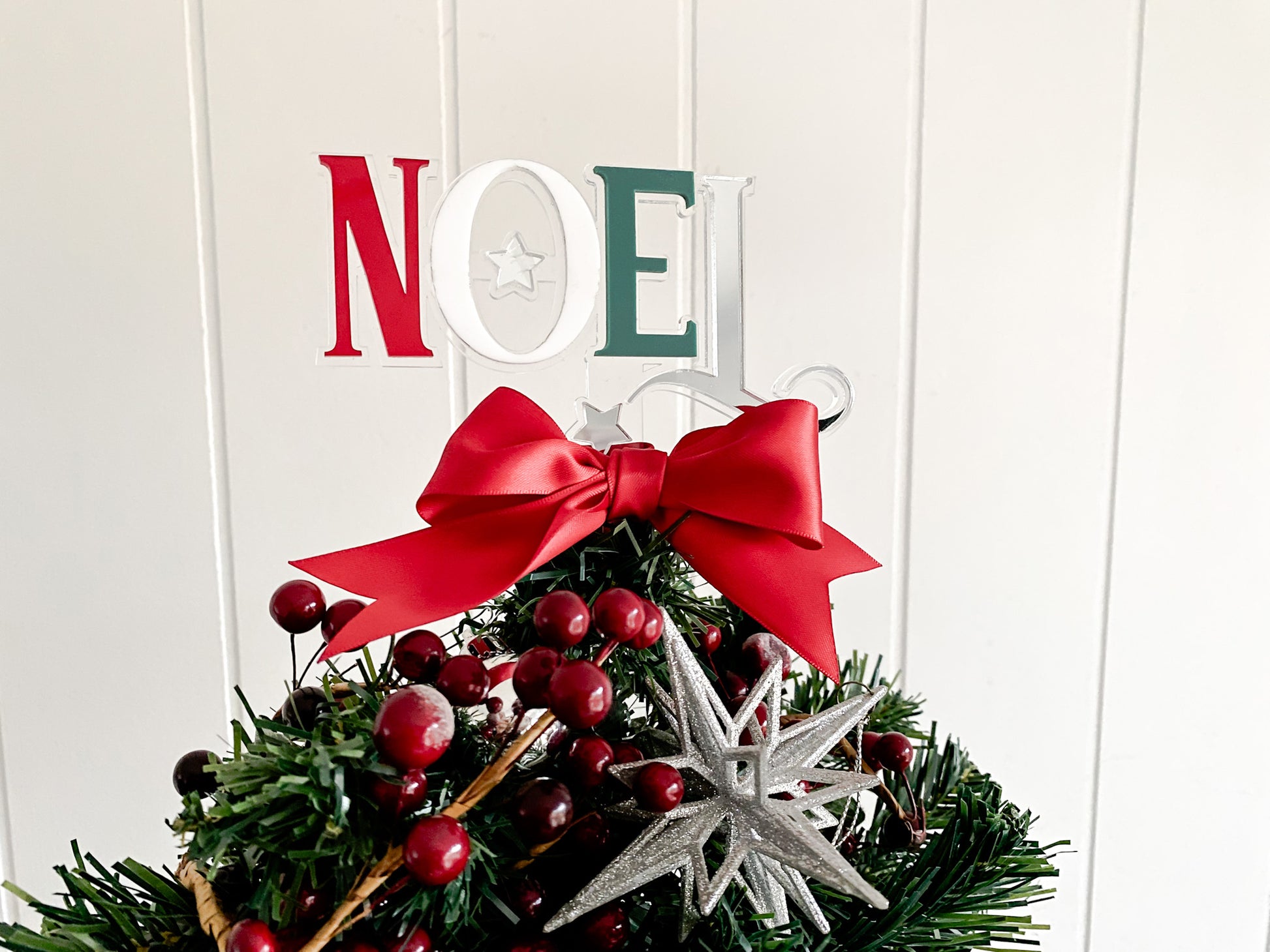 Elegant Noel Christmas Tree Topper made from layered acrylic in festive red, white, and green tones, finished with a luxurious red satin bow. A modern take on traditional décor, this handmade design adds a touch of sparkle and sophistication to your tree. Perfect for Australian Christmas styling or gifting this holiday season.