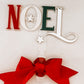 Handcrafted Noel tree topper featuring layered acrylic lettering in festive hues and a statement red ribbon. Designed by Bell & Beau Design Co to bring modern elegance to your Christmas décor. Lightweight, easy to attach, and made to last — a perfect keepsake for years of festive celebrations.