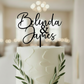 Personalised acrylic wedding cake topper in modern script font featuring custom names. Elegant, laser-cut cake decoration designed to suit weddings, engagements, anniversaries, and special events. Lightweight yet durable acrylic makes it the perfect keepsake. Stylish black lettering enhances your cake display, ideal for couples seeking custom wedding décor and unique personalised details.