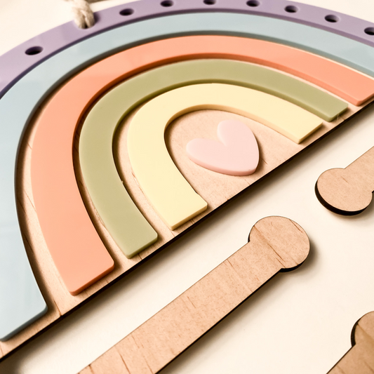 Personalized baby girl nursery gift: A custom wooden rainbow organizer for storing headbands and bows in a modern, neutral bedroom.
