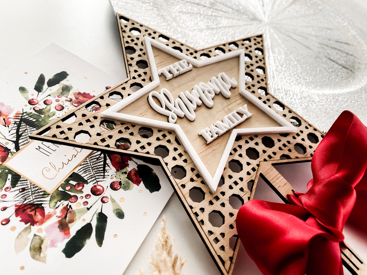 Wooden rattan star Christmas topper with personalised family name, red ribbon tie, eco friendly holiday décor, handmade in Australia.