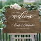 ustom wooden wedding welcome sign in dark stain with white script for the names Mindy & Christopher and wedding date.