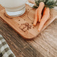 Christmas Eve treat board styled with milk glass, cookies, and carrot for the reindeer. Natural bamboo tray engraved with “Dear Santa”. Captures the excitement of children preparing for Santa’s visit — a heartfelt, reusable keepsake for family Christmas traditions.