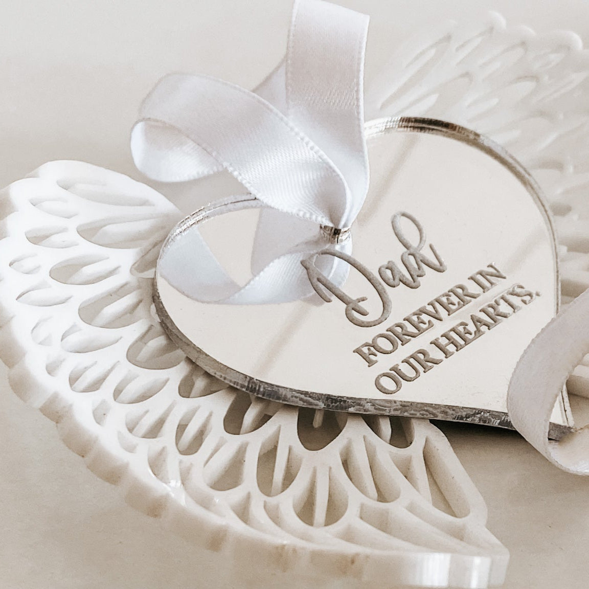 White angel wings with silver heart centre.  Hanging ornament complete with white sating ribbon. Perfect sympathy or remembrance gift. 