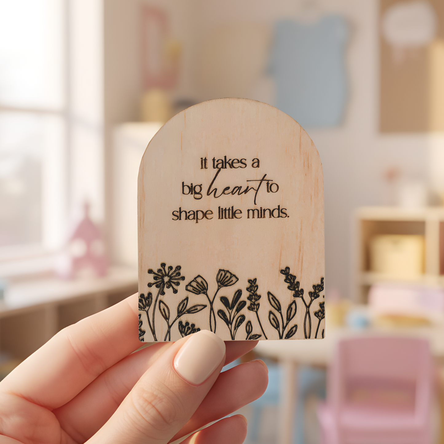 Engraved wooden arch magnet with floral detail and quote “it takes a big heart to shape little minds,” teacher appreciation keepsake.