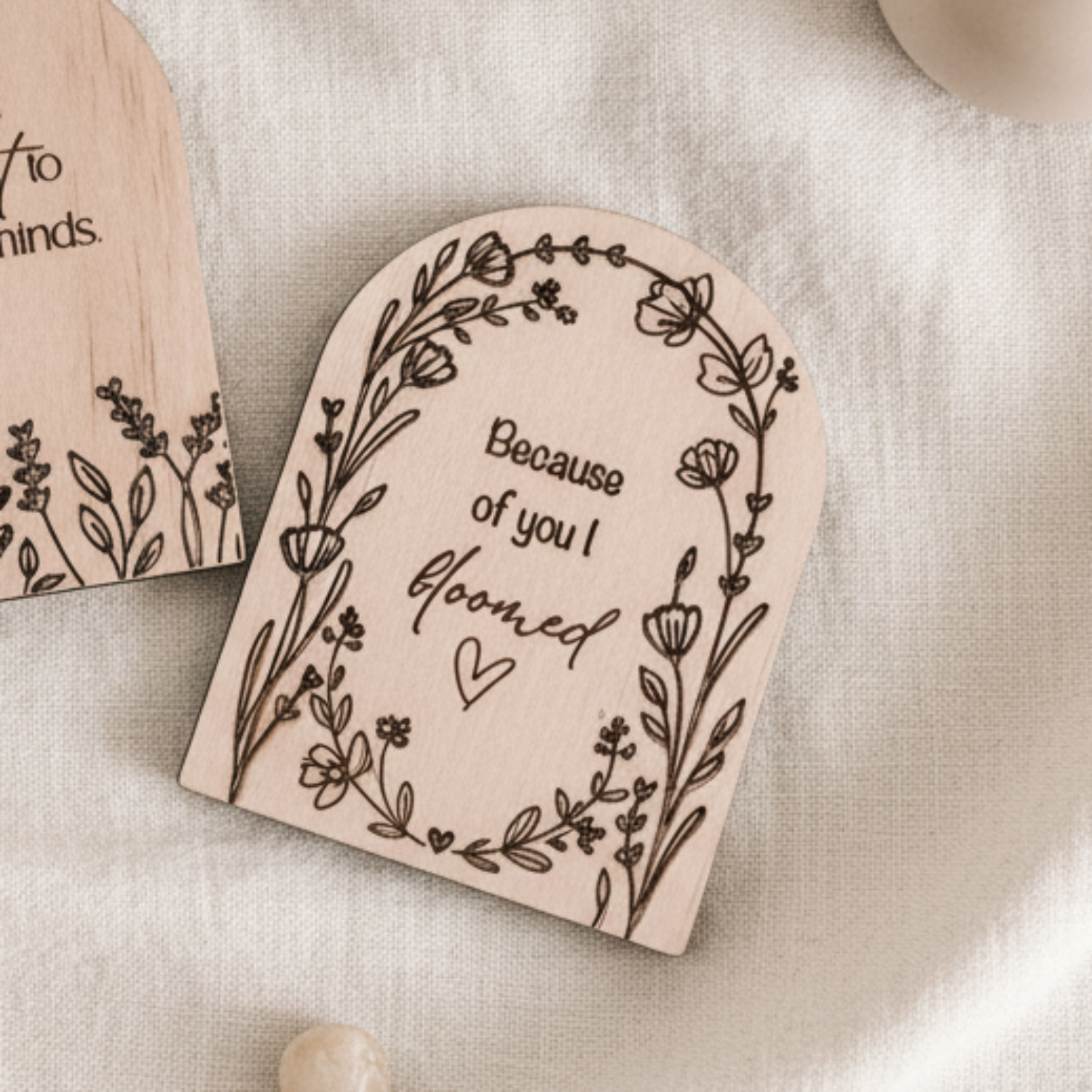 Close-up of a small plywood magnetic keepsake with the phrase "because of you I bloomed," used as a meaningful Teacher Appreciation Gift.