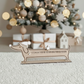 Wooden Dachshund Christmas Countdown Calendar with a beanie and a movable star against a white shaggy background.