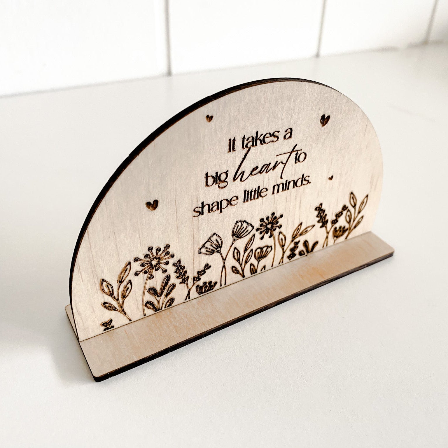 Close-up of a wooden teacher appreciation plaque, featuring a floral motif and hidden personalization option on the reverse side.