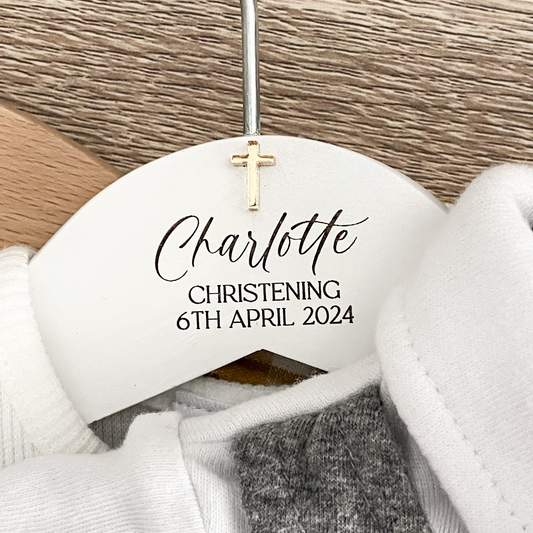 White hanger with 'Charlotte Christening 6th April 2024' text on a wooden background