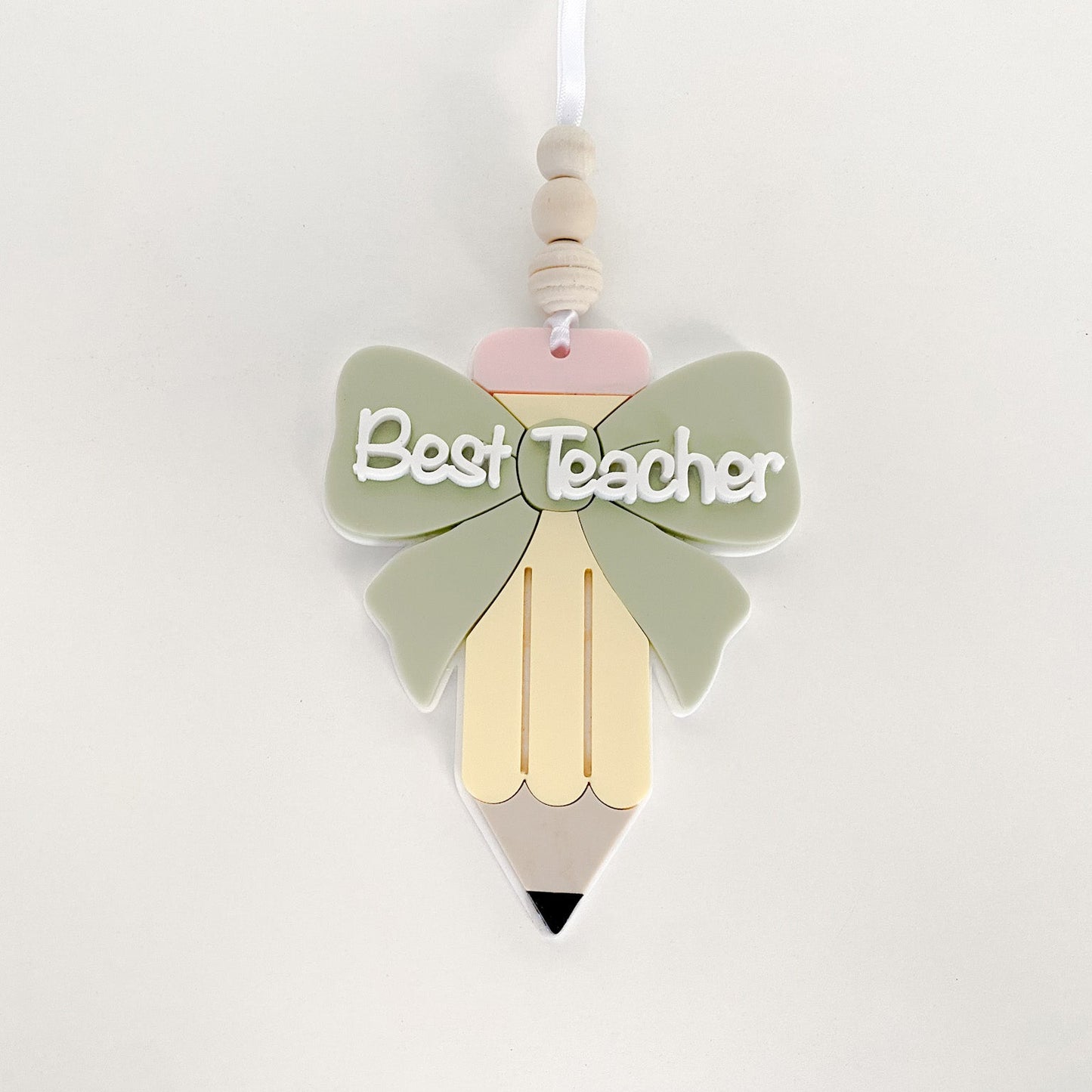 layered acrylic teacher appreciation ornament with a green bow and the words Best Teacher