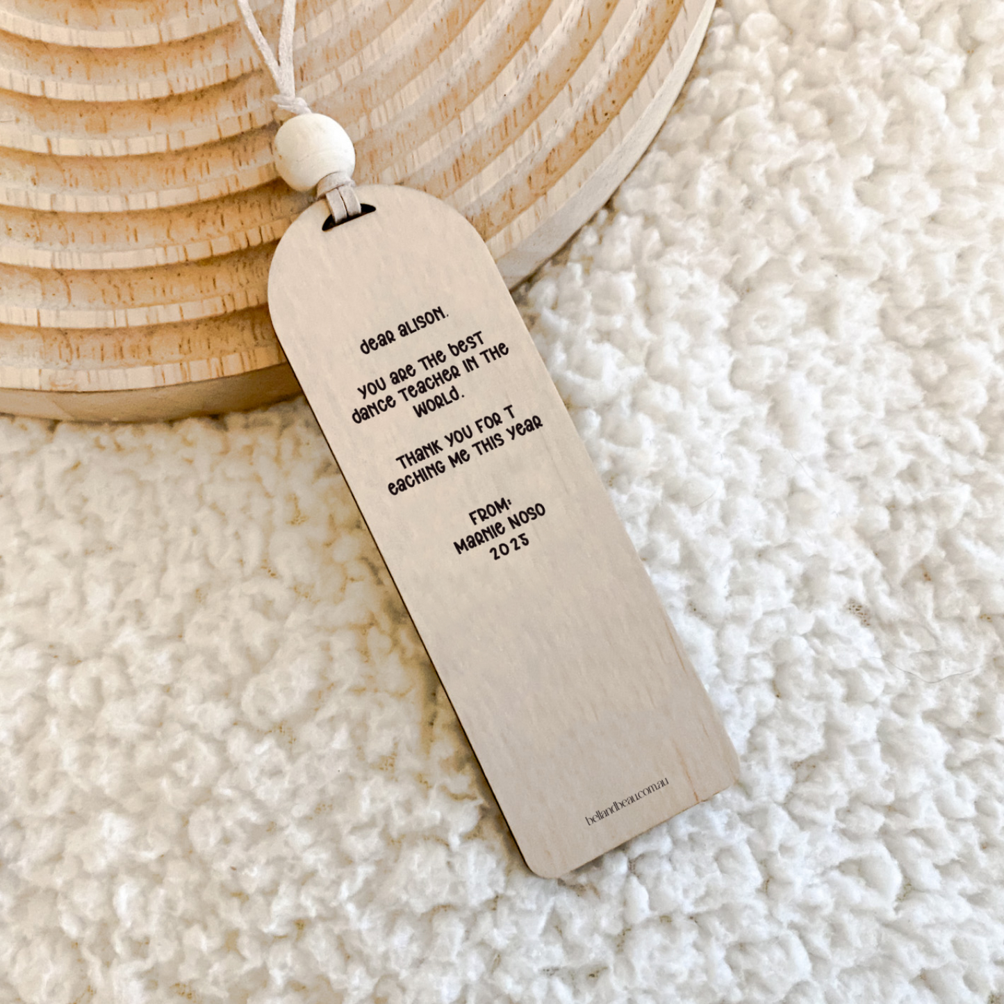 A charming wooden bookmark with a natural string and bead, perfect as a bee-themed teacher present.