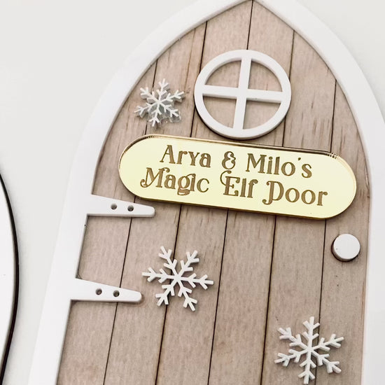 Video of Modern Christmas Elf Door crafted from acrylic with layered textures and snowflake details. Personalised name plaque adds a heartfelt touch. Ideal for placing near the Christmas tree or on a skirting board to delight children.