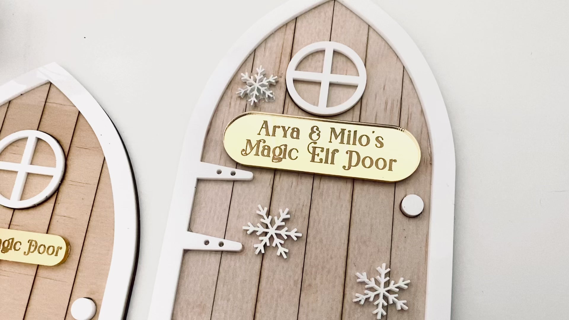 Video of Modern Christmas Elf Door crafted from acrylic with layered textures and snowflake details. Personalised name plaque adds a heartfelt touch. Ideal for placing near the Christmas tree or on a skirting board to delight children.